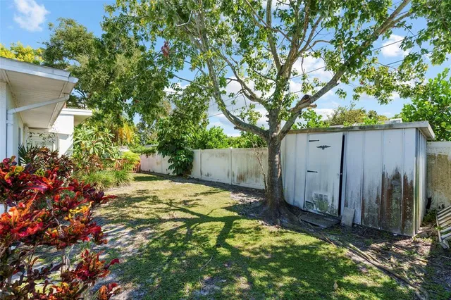 a view of a house with a tree and garden