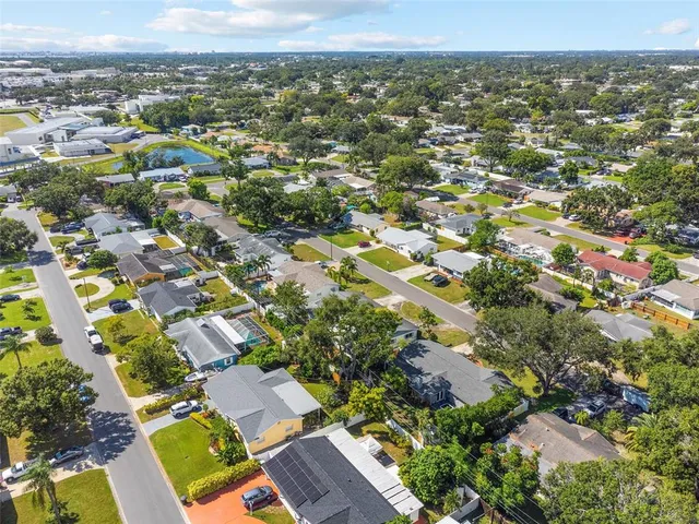 an aerial view of residential houses with outdoor space and parking