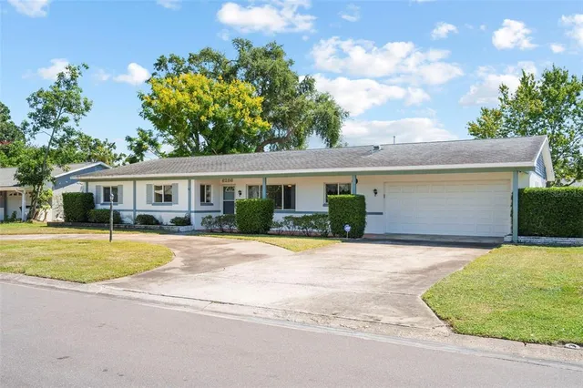 a front view of house with yard and trees around