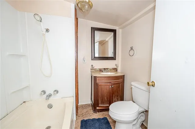 a bathroom with a granite countertop toilet a sink and a bathtub