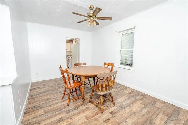 a view of a dining room with furniture and a chandelier fan