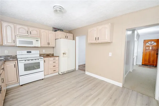 a kitchen with white cabinets and white stainless steel appliances