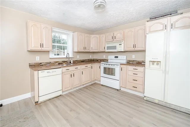 a kitchen with white cabinets sink and white appliances