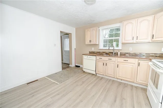 a view of a kitchen with wooden floor and electronic appliances