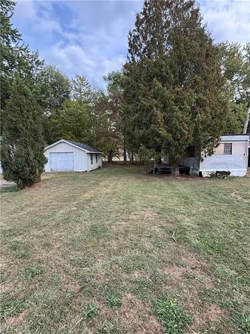 a view of a yard with a bench and trees