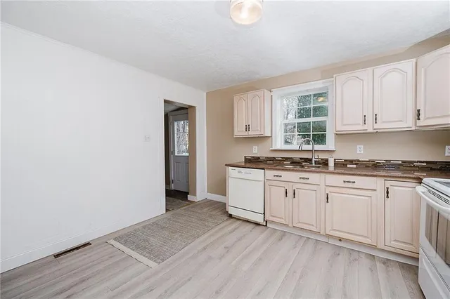 a kitchen with granite countertop white cabinets and white appliances
