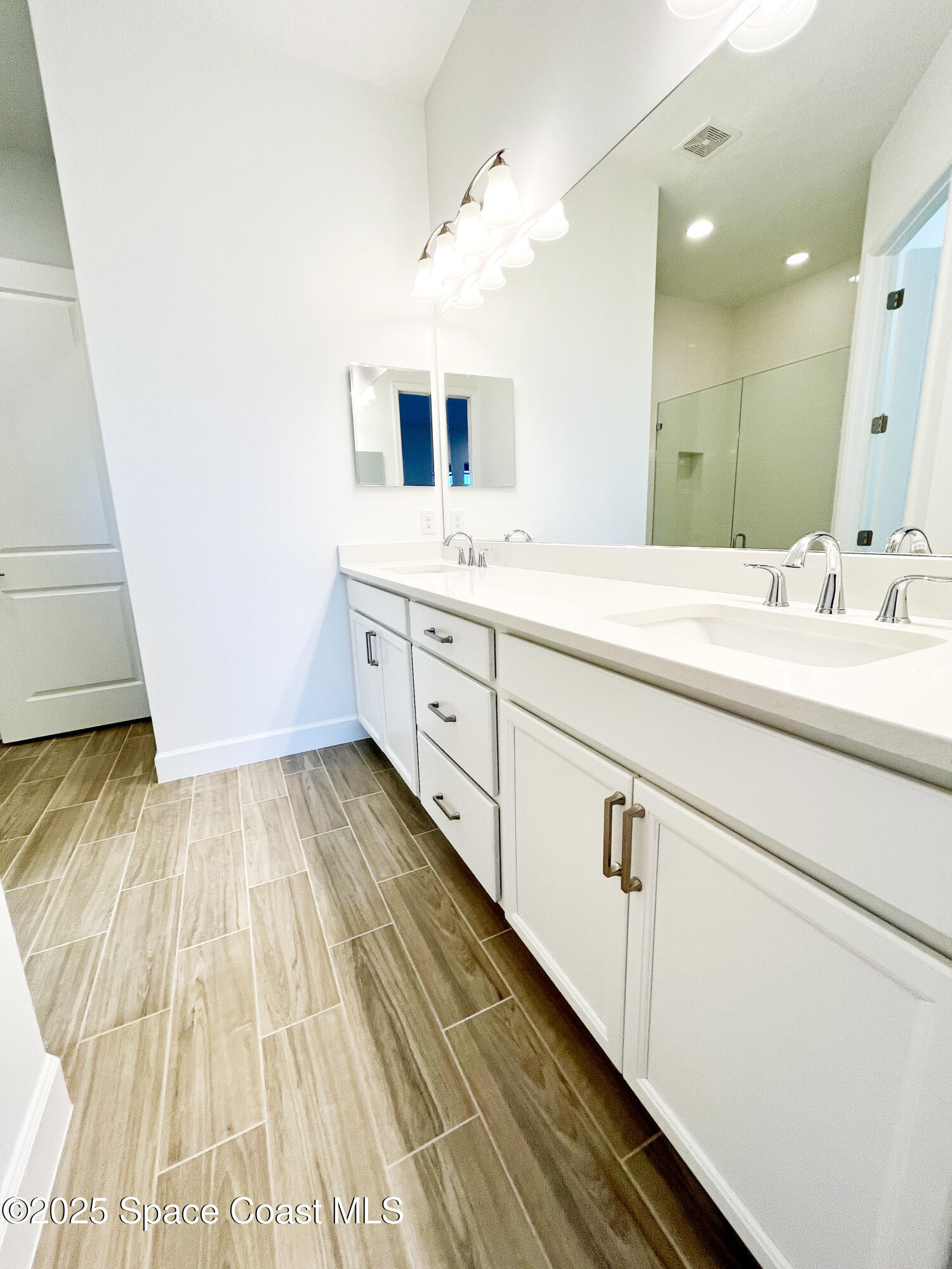 7707 Cache Crk Lane Melbourne, FL 32940 - Photo 12 of 18 a spacious bathroom with a sink and mirror