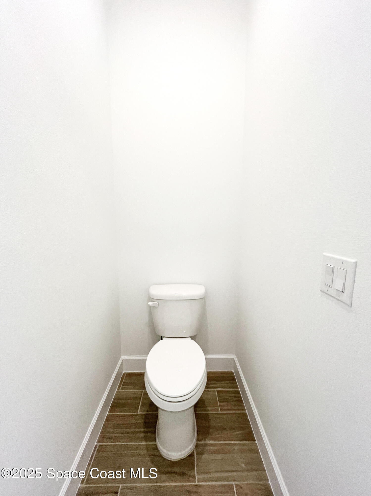 7707 Cache Crk Lane Melbourne, FL 32940 - Photo 14 of 18 a white toilet sitting next to a white wall