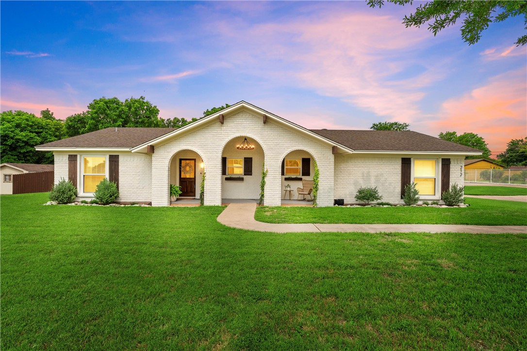 a front view of a house with a garden and yard