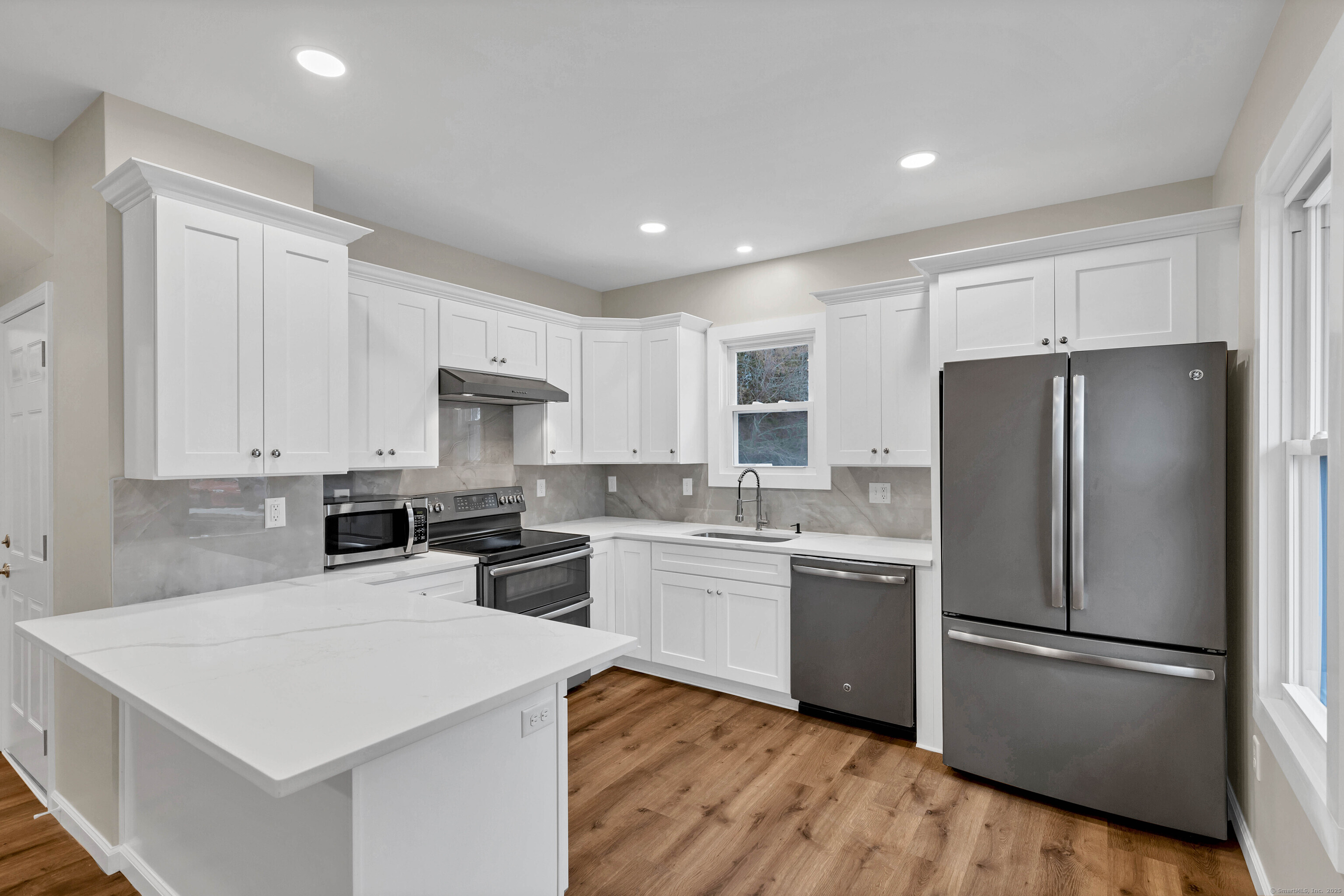 191 B Boston Post Road East Lyme, CT 06333 - Photo 1 of 1 a kitchen with a refrigerator a sink and white cabinets