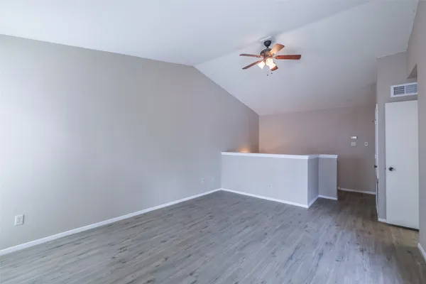 a view of a room with wooden floor and a ceiling fan