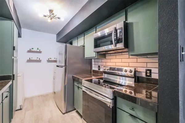 a kitchen with stainless steel appliances granite countertop a stove and a microwave