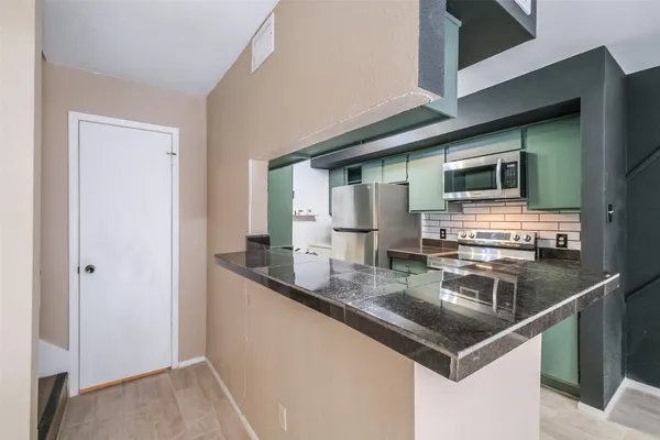 a kitchen with stainless steel appliances granite countertop a sink and a refrigerator