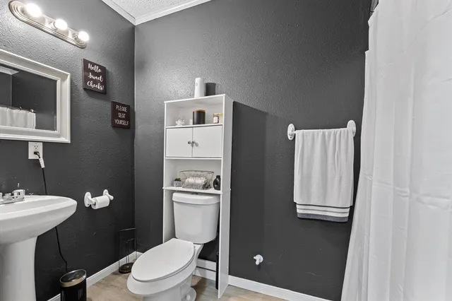 a bathroom with a toilet a sink and mirror