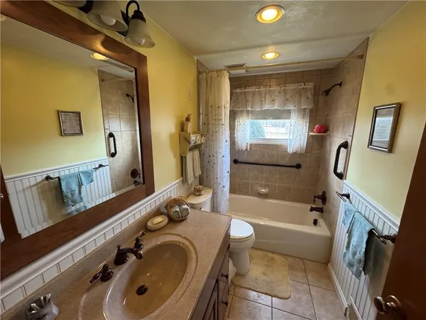 a bathroom with a tub a sink and a large mirror
