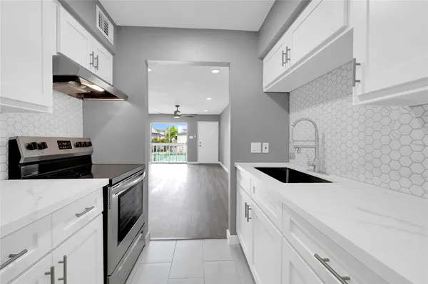 a kitchen with a sink a stove and cabinets