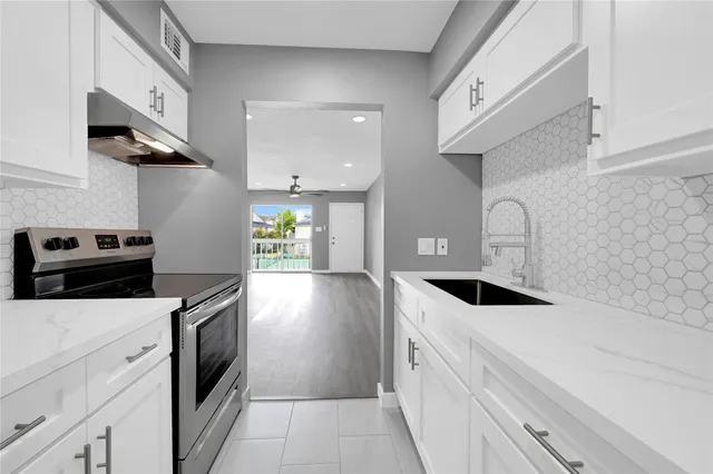 a kitchen with a sink a stove and cabinets