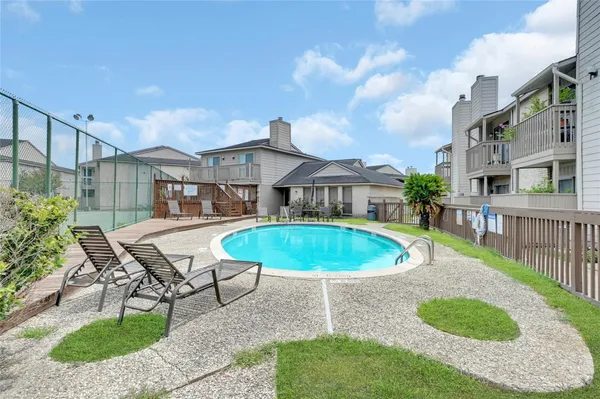 a view of a house with a swimming pool and sitting area