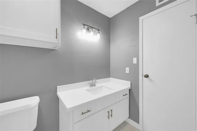 a bathroom with a sink a toilet and a mirror