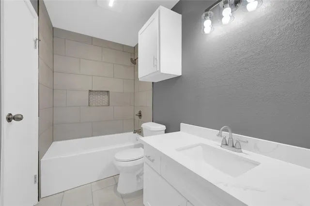 a bathroom with a toilet a sink a mirror and bathtub