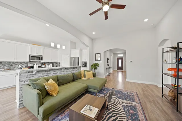 a living room with furniture and a wooden floor