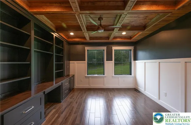 a large kitchen with stainless steel appliances kitchen island granite countertop a refrigerator a stove a sink a dining table and chairs with wooden floor