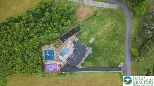 an aerial view of a house with a garden and lake view