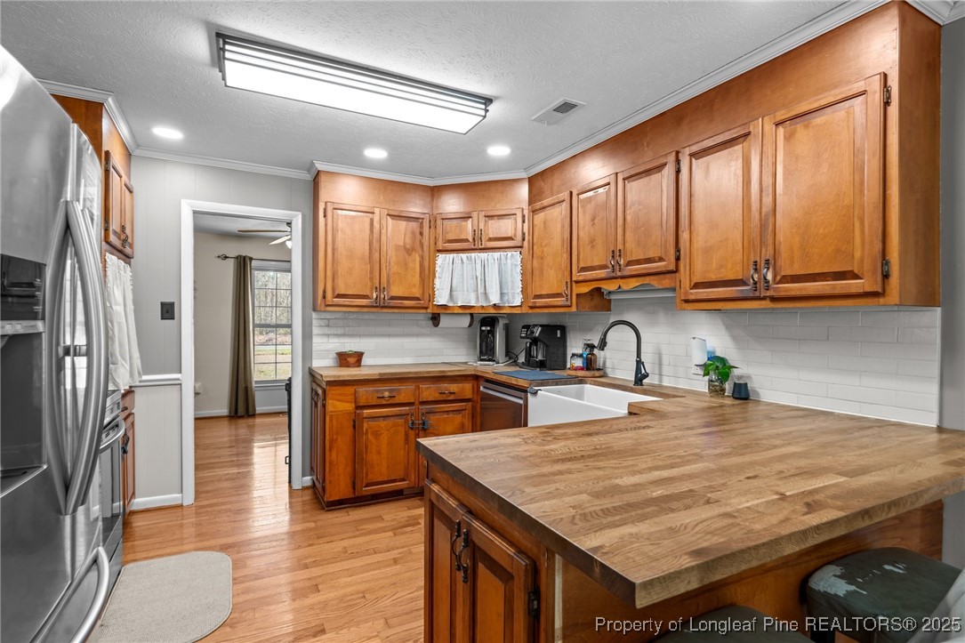 1284 Old Stage Road Fairmont, NC 28340 - Photo 15 of 48 a kitchen with stainless steel appliances granite countertop wooden cabinets a refrigerator and a stove top oven