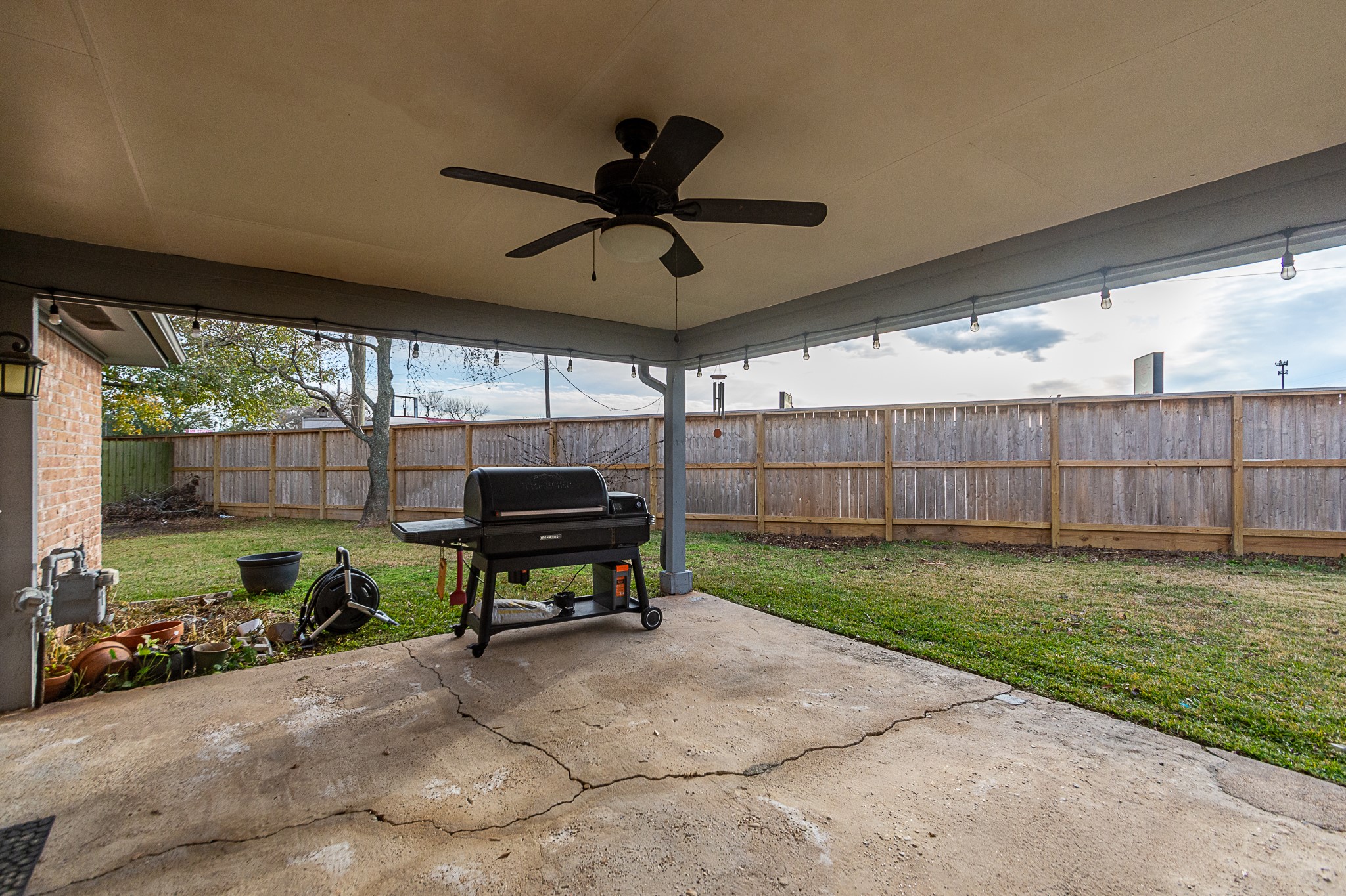 4830 Lost Oak Drive Spring, TX 77388 - Photo 37 of 41 This photo showcases a spacious backyard with a well-maintained lawn, bordered by a wooden fence. The area includes mature trees, offering shade and privacy, and the exterior of a brick house is partially visible. Ideal for outdoor activities and relaxation.
