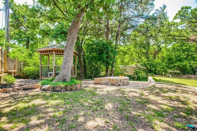 a view of a backyard with a barbeque grill and wooden fence