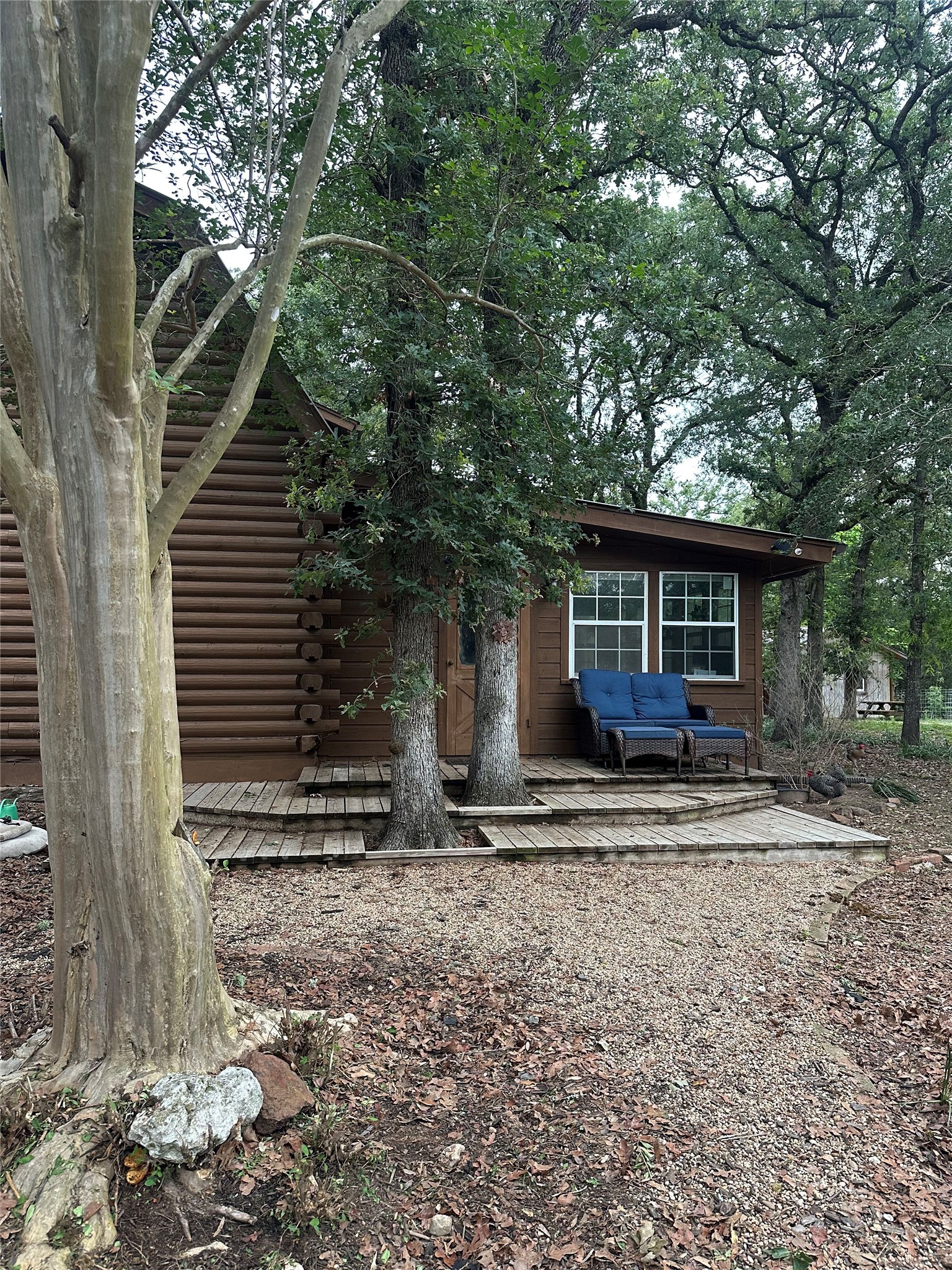 1053 East County Rd F Lexington, TX 78947 - Photo 19 of 38 a view of a house with a yard tree and a wooden fence