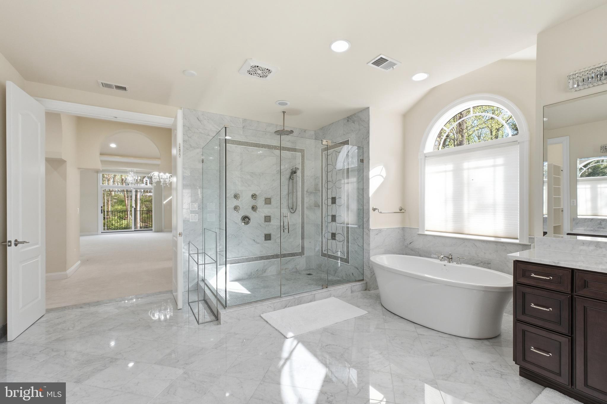 8735 Brook Road McLean, VA 22102 - Photo 16 of 20 a spacious bathroom with a bathtub shower and mirror