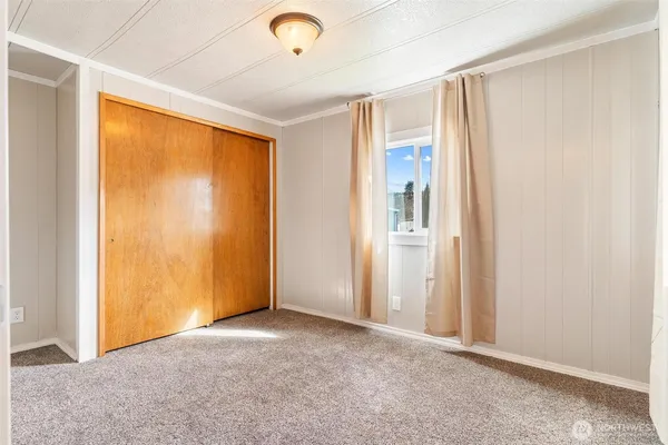an empty room with windows and closet
