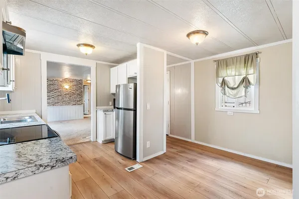 a view of a refrigerator in kitchen and wooden floor