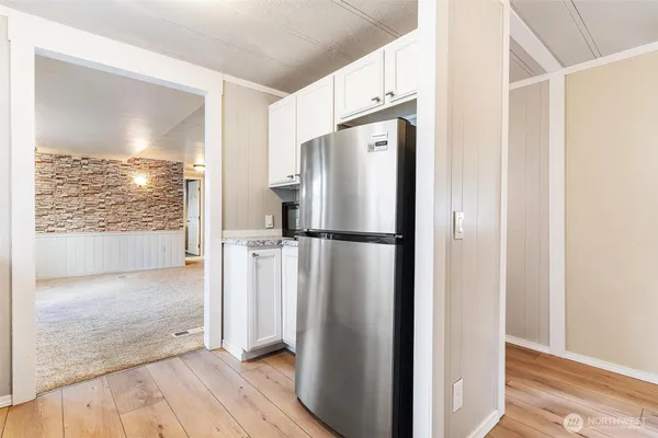 a view of a kitchen with wooden floor and a refrigerator