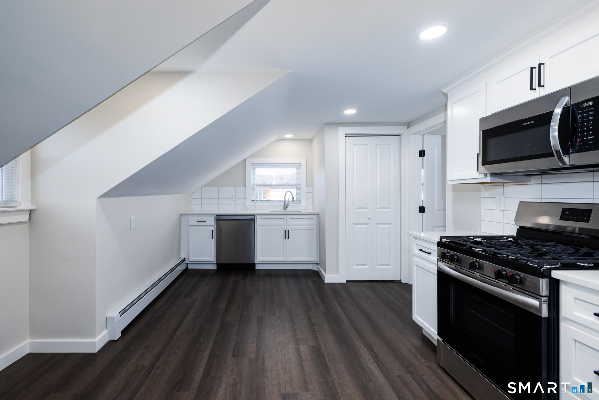 a kitchen with stainless steel appliances a white cabinet and a stove top oven