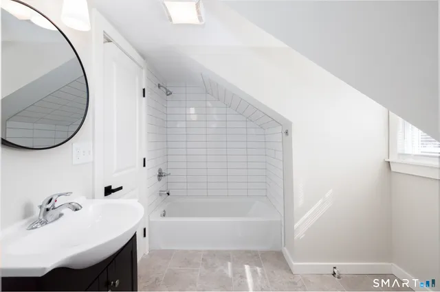a bathroom with a sink a bathtub and a mirror