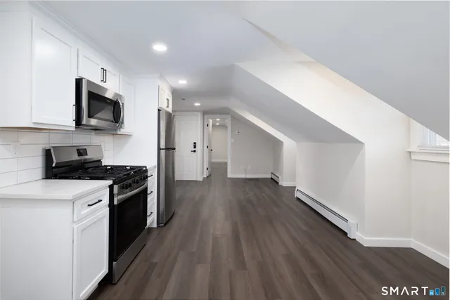 a kitchen with stainless steel appliances a stove top oven a sink and a refrigerator