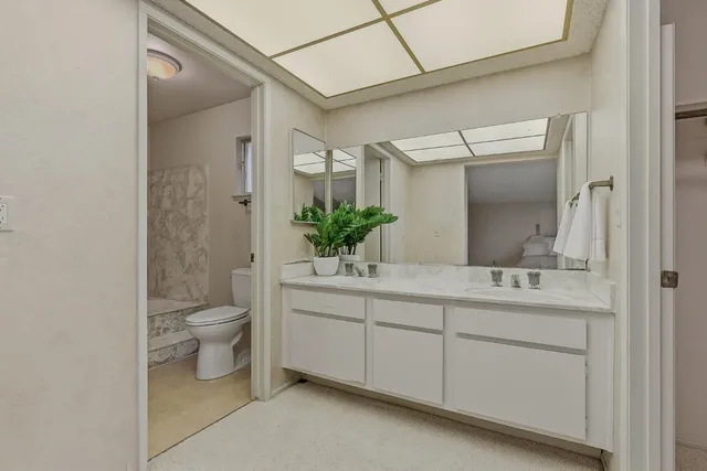 a bathroom with a double vanity sink toilet and shower
