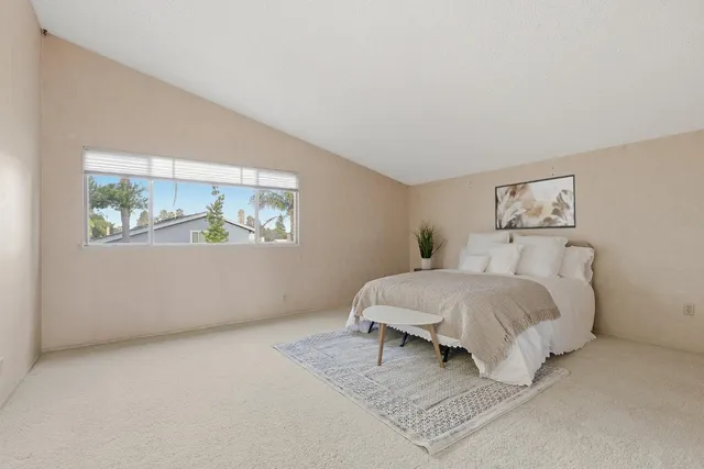 a bed room with a bed and painting on the wall