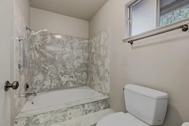 a bathroom with a toilet and shower