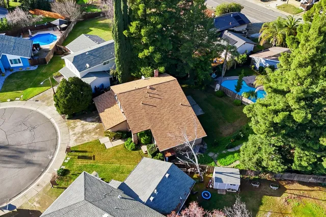 an aerial view of a house with a garden and swimming pool