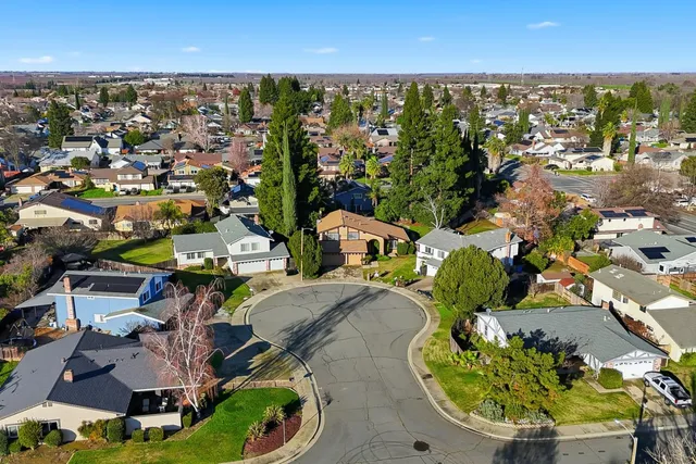 an aerial view of a house with a swimming pool a yard and mountain view in back
