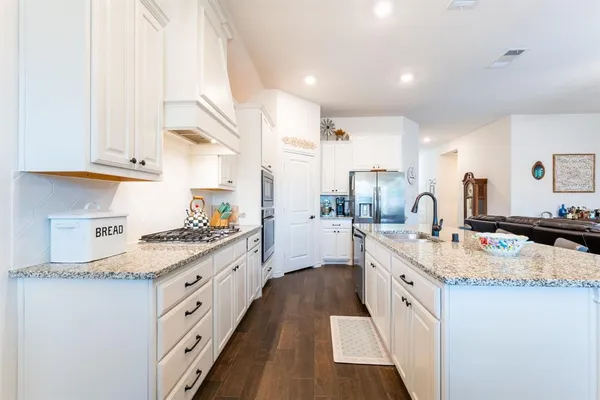 a kitchen with granite countertop a sink stove and cabinets
