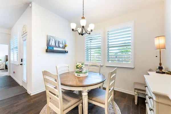 a dining room with furniture a chandelier and wooden floor