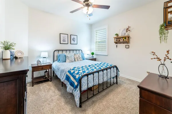 a bedroom with a bed and a table with potted plants