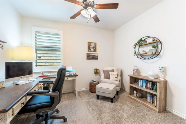 a view of a workspace with furniture and a window