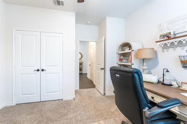 a view of a workspace with furniture and a window