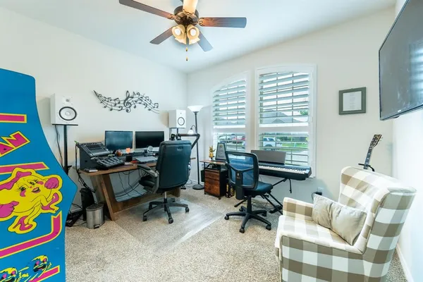 a view of a workspace with furniture and a window