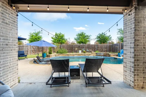 a view of patio with table and chairs under an umbrella